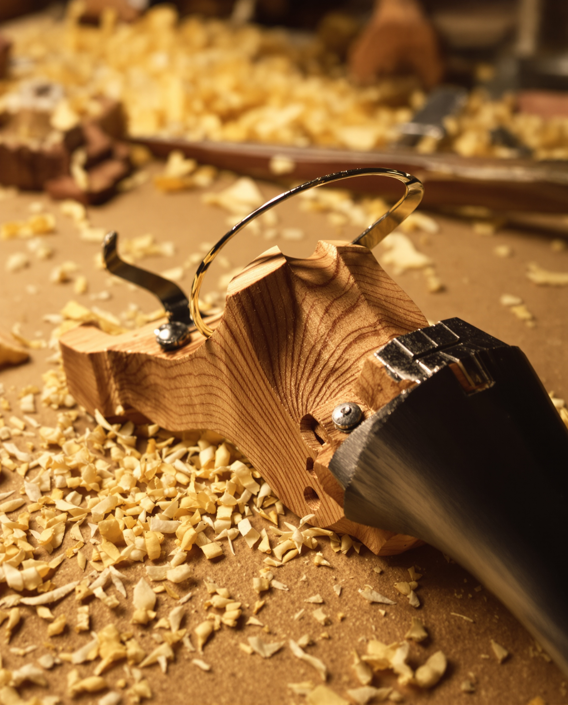 Gros plan sur un chevalet en érable sculpté à la main sur établi de luthier