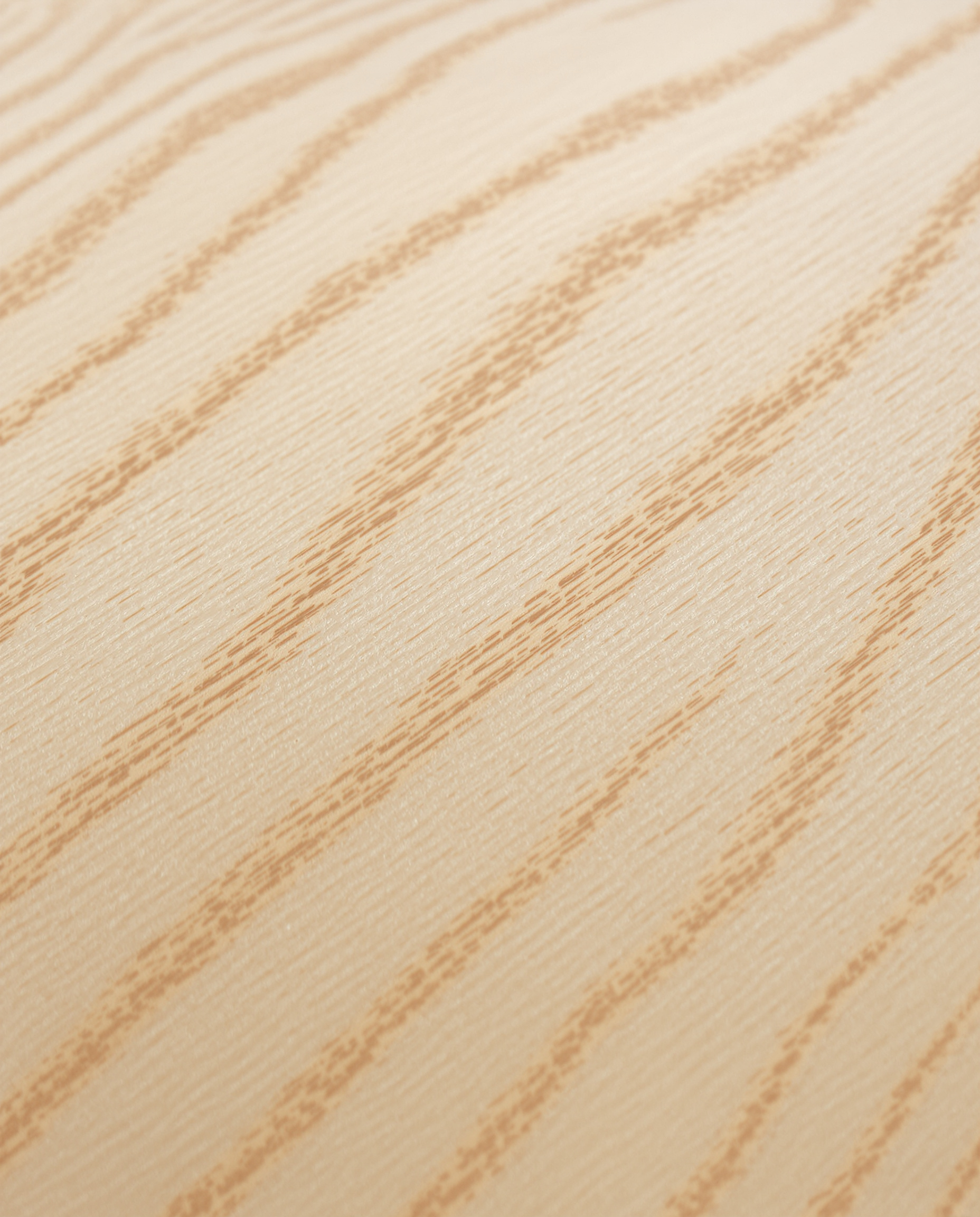Gros plan sur une table d'harmonie en épicéa de haute qualité, montrant la finesse du grain et ses reflets lumineux.